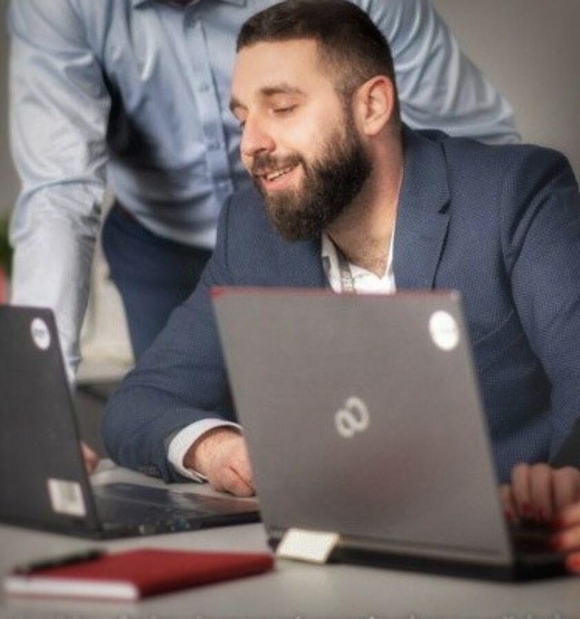 Hipolit Badowski working with a team at a table with laptops